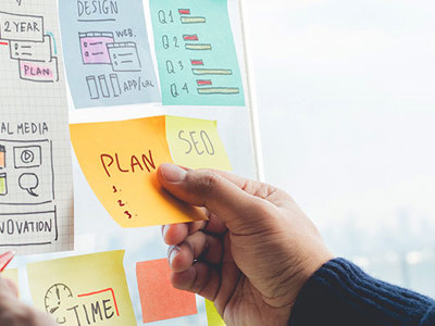 Photo of post-it notes on a wall planning out a marketing campaign. 